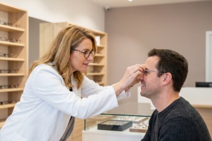 Opticienne ajustant des lunettes à un client dans une boutique moderne du Finistère